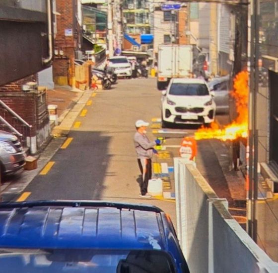 21일 서울 봉천동에서 60대 남성이 농약살포기로 추정되는 물건으로 불꽃을 발사하고 있다. [뉴스1]