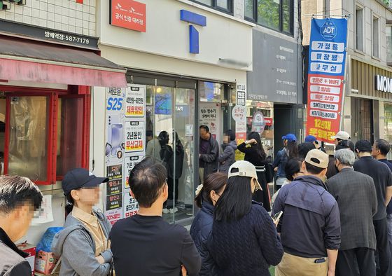 지난 26일 서울 시내 한 SKT 대리점에서 고객들이 유심을 교체하기 위해 줄을 서 기다리고 있다. 연합뉴스