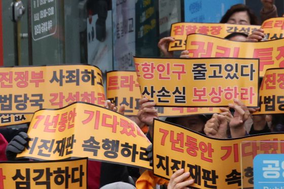 경북 포항지진 범시민대책본부와 120개 사회·종교·봉사단체가 지난해 11월 15일 포항 중앙상가에서 개최한 시민 궐기대회에서 참가자들이 손팻말을 들고 재판 진행을 촉구하고 있다. 연합뉴스