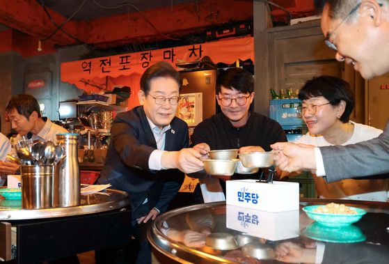 이재명 더불어민주당 대선 후보가 1일 서울 종로구의 한 포차 식당에서 '당신의 하루를 만드는, 보이지 않는 영웅들'이란 주제로 배달 라이더, 택배 기사 등 비(非)전형 노동자들과 간담회를 하며 잔을 부딪치고 있다. 연합뉴스