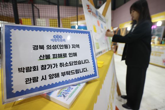 지난 3월 27일 서울 강남구 SETEC에서 열린 '2025 내나라 여행 박람회'에 마련된 안동소주 부스에 산불 피해로 인해 참가 취소 안내문과 응원 메시지판이 내걸려 있다. 연합뉴스