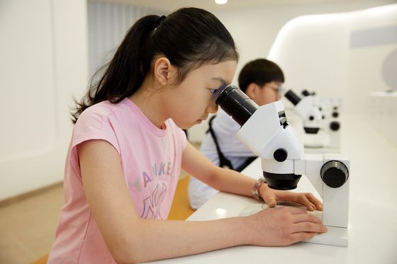 현미경을 통해 유산균을 관찰하는 소중 학생기자단.