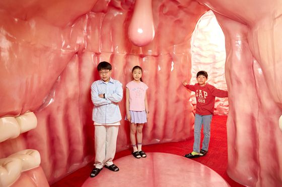 박준후 학생기자·임서희 학생모델·김산하(왼쪽부터) 학생기자가 입과 위, 장을 재현해 놓은 방에 들어가 유산균이 어떤 역할을 하는지 체험했다.