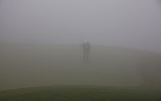 15일 개막 예정이던 KPGA 투어 SK텔레콤 오픈이 대회장인 제주 서귀포 핀크스 골프 클럽 일대의 짙은 안개로 인해 하루 순연됐다. 짙은 안개 속에서 그린 컨디션을 살피는 대회 관계자. 사진 KPGA