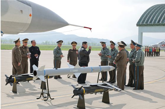 김정은 북한 국무위원장이 지난 15일 북한군 제1공군사단 예하 비행연대를 방문해 신형 중거리 공대공 미사일을 옆에 두고 간부들에게 지시를 내리는 모습. 노동신문, 뉴스1
