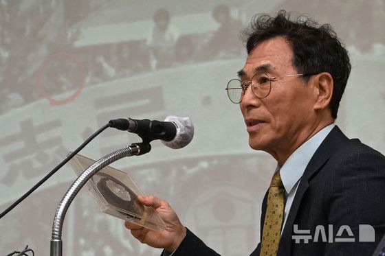 광주시민 문제성씨가 27일 오전 광주 동구 5·18민주화운동기록관에서 열린 시사회에 참여해 자신이 5·18 당시 촬영한 필름을 들어올리며 설명하고 있다. 뉴시스