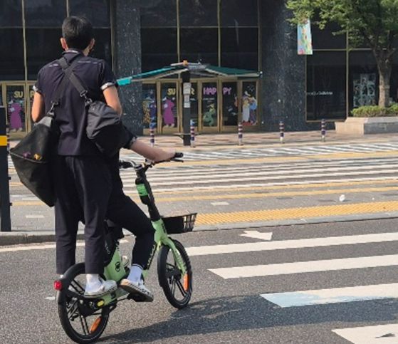 28일 오전 8시쯤 부산 서면에서 부산시가 투입한 비상 전세버스를 기다리던 고교생들이 공유형 자전거를 타고 등교하고 있다. 김민주 기자