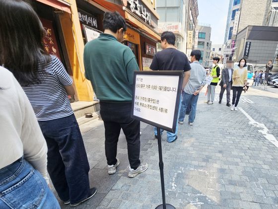 제21대 대통령선거 사전투표가 시작된 29일 낮 서울 중구 소공동 사전투표소 앞 관외 대기줄 표지판 근처에서 직장인 등 유권자들이 줄 서 대기하고 있다. 신혜연 기자