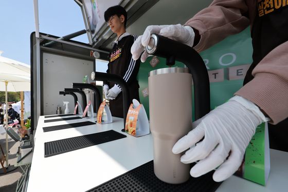 서울 영등포구 여의도공원에서 열린 2025 지구의 날 기념행사에서 부스 관계자가 텀블러를 가져온 시민에게 음료를 따라주고 있다. [연합뉴스]