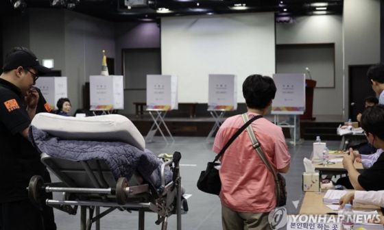 제21대 대통령선거일인 3일 서울 용산구 중부기술교육원에 마련된 한남동 제3투표소에서 한 환자가 보호자와 구급대원의 도움을 받아 투표에 참여하고 있다. 연합뉴스