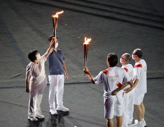 23일 일본 도쿄 올림픽스타디움에서 열린 2020도쿄올림픽 개막식에서 일본 프로야구 감독 및 선수 출신인 오 사다하루(오른쪽부터), 나가시마 시게오, 마쓰이 히데키가 코로나19 치료를 담당하는 의사와 간호사에게 성화를 전달하고 있다. 있다. 코로나19의 세계적 대유행으로 예정보다 1년 늦게 막을 올린 도쿄올림픽 개막식에는 IOC 관계자, 외교사절 등 1천명 정도의 인원만 직접 자리를 지켰다. 2021.07.23 도쿄=올림픽사진공동취재단S