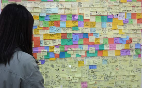 서울 종로구 적선현대빌딩에서 열린 10.29 이태원참사 기억소통공간 '별들의집' 개소식을 찾은 시민들이 추모메시지를 살펴보고 있다. [연합뉴스]