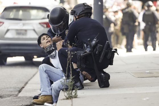 현지시간 8일 로스앤젤레스 시내에서 시위대 중 한 명이 체포되고 있다. AP=연합뉴스