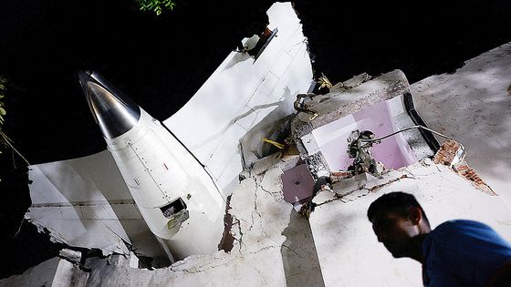 지난 12일(현지시간) 인도 북서부 구자라트주 아메다바드에서 추락한 비행기 잔해 주위에 사람들이 서 있다. AP=연합뉴스