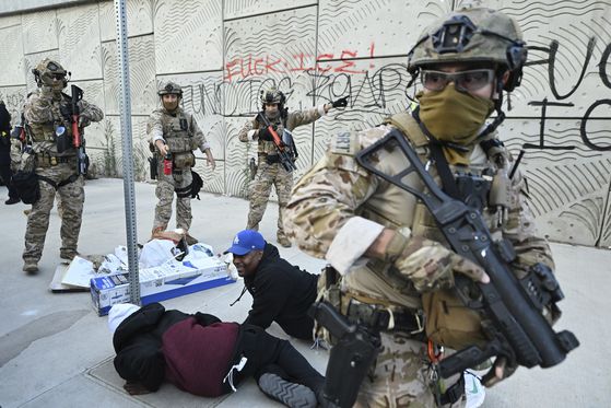 미국 세관국경보호국 요원들이 12일(현지시간) 로스앤젤레스에서 시위대를 해산시키고 있다. AP=연합뉴스