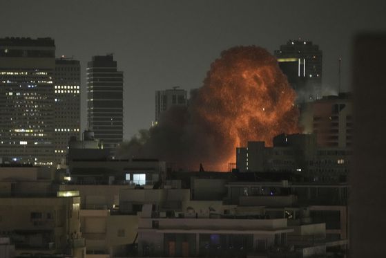 지난 15일(현지시간) 이스라엘 텔아비브에서 요격망을 돌파한 이란의 미사일이 도심을 타격해 화염을 뿜고 있다. AP=연합뉴스