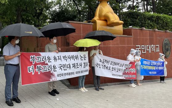 지난 2022년 8월, 국민대 정문 앞에서 국민대 동문 비상대책위원회가 윤석열 대통령 부인 김건희 여사가 2007년 쓴 박사학위 논문조사 결과에 항의하는 현수막을 들고 시위를 하고 있다. 연합뉴스