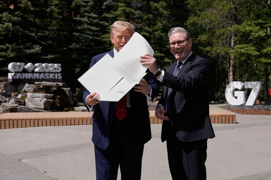 트럼프와 키어 스타머 영국 총리(오른쪽)가 16일(현지시간) G7 정상회의에서 무역협정에 합의하고 있다. AP=연합뉴스