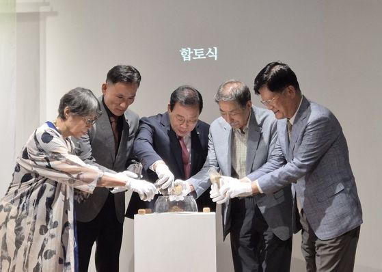 18일 장욱진 생가기념관 착공식에서 관계자들이 장욱진이 생전에 머물던 곳들의 흙을 한데 모으고 있다. 왼쪽부터 장욱진의 장녀 장경수, 윤지성 세종시의원, 최민호 세종특별자치시장, 장남 장정순, 김동건 장욱진미술문화재단 이사장. 세종=권근영 기자