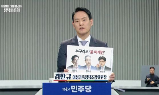 김한규 더불어민주당 의원이 지난 5월 2일 중앙선거관리위원회가 주관한 대선 정책 토론회에 참석해 ‘누구라도 윤어게인’이라는 문구가 인쇄된 팻말을 들어 보이고 있다. [사진 김한규 페이스북]