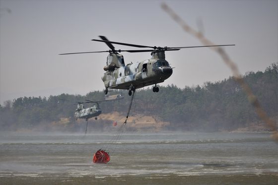 육군 치누크 헬기(CH-47)가 지난 3월 27일 경북 의성군 안계면 개천저수지에서 밤비바켓(물주머니)에 산불 진화용 물을 급수하고 있다. 육군 제공