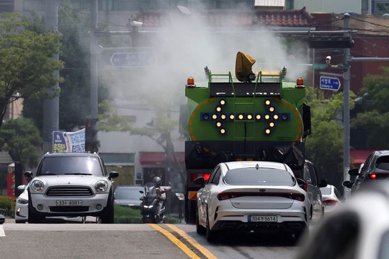 낮 기온이 30도를 웃돌아 무더운 날씨를 보인 26일 광주 북구청 기후환경과 직원들이 살수차를 이용해 도로의 지열을 식히고 있다. 광주 북구 제공