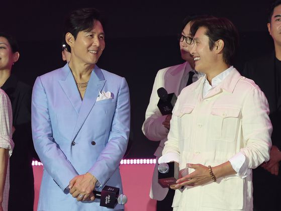배우 이정재(왼쪽)과 이병헌이 28일 오후 서울광장에서 열린 오징어게임 시즌3 글로벌 피날레 무대인사에서 대화 중이다. 사진 뉴스1