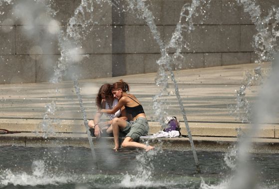 25일 미국 워싱턴 DC에서 미국 동부를 강타하는 위험한 폭염 속에서 한 커플이 제2차 세계대전 기념관 분수에서 몸을 식히며 포옹하고 있다. 로이터=연합뉴스
