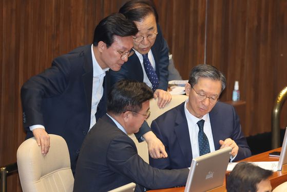 2019년 12월 10일 당시 홍남기 경제부총리 겸 기획재정부 장관이 국회 본회의장에서 자신의 의원석으로 가려고 일어선 유은혜 사회부총리 겸 교육부 장관과 대화하고 있다. 연합뉴스