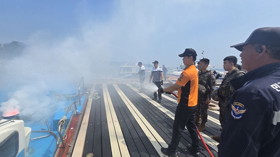 7일 오전 충남 태안군 영목항에서 열린 선박 화재 진압 훈련에서 119소방대와 해경이 호스를 이용해 불을 끄고 있다. 신진호 기자