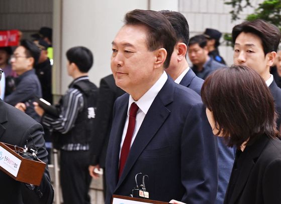 윤석열 전 대통령이 국민의힘 탈당 이틀 후인 지난 5월 19일 오전 서울 서초구 중앙지방법원에서 열린 내란 우두머리 혐의, 직권남용 권리행사방해 혐의 사건 4차 공판에 출석, 취재진의 질문을 받으며 이동하고 있다. 사진공동취재단
