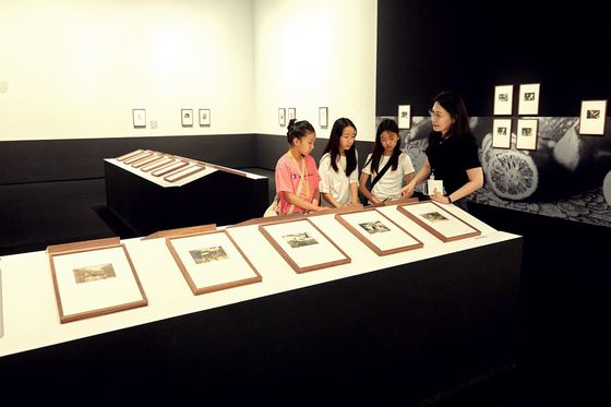 손현정(맨 오른쪽) 학예연구사가 소중 학생기자단에게 '광채: 시작의 순간들' 전시에 소개된 여러 작가에 관해 설명했다.