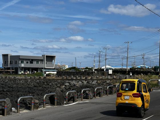 우도 해안도로를 운행 중인 전기 삼륜차. 최충일 기자