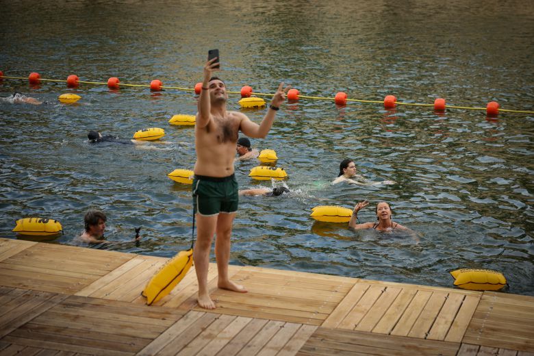 센강 수영장 3곳이 개장한 지난 5일(현지시간) 프랑스 파리 센강 브라 마리 안전 수영장에서 한 남성이 수영하는 사람들을 바라보며 사진을 찍고 있다. AP=연합뉴스