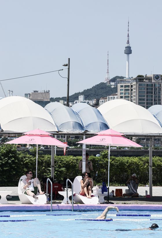 잠원 수영장 너머로 남산 서울타워가 보인다. 핑크빛 파라솔은 지드래곤이 설립한 저스피스 재단의 조언을 받아 색을 선정했다. 김경록 기자