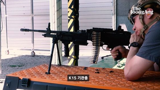 기자가 K16 기관총을 쏘고 있다. 왼쪽에 탄피가 날아가는 장면이 찍혔다. 화면 캡처