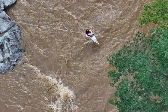 20일 경기도 가평군의 한 캠핑장에서 불어난 강물에 고립됐던 시민이 소방 로프를 타고 탈출하고 있다. [뉴스1]