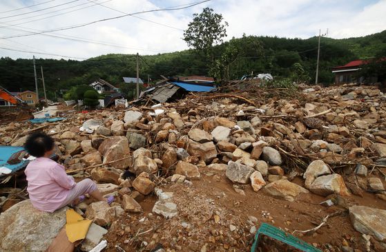 20일 경남 산청군 산청읍 외정마을의 한 주민이 돌밭으로 변한 마을을 바라보며 망연자실해 하고 있다. 지난 16일부터 ‘극한 호우’가 내린 산청군에서는 산사태와 침수가 잇따르고, 10명이 숨지고 4명이 실종되는 인명피해까지 발생했다. [뉴스1]