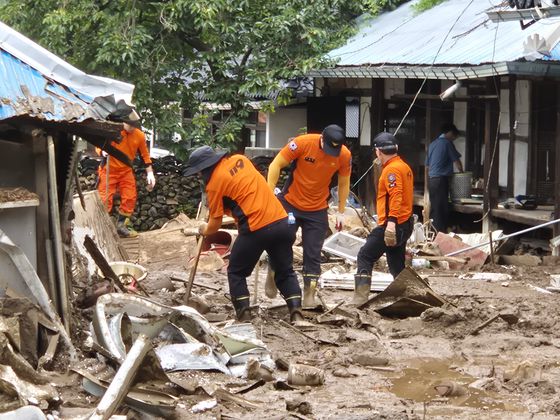 21일 오전 경남 산청군 모고리 모고마을 아래 논밭에서 한 소방대원이 나무 막대기를 들고 수색 작업을 벌이고 있다. 안대훈 기자