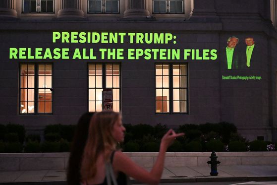 도널드 트럼프 미국 대통령(오른쪽)과 제프리 엡스타인의 사진과 함께 트럼프 대통령에게 엡스타인 스캔들과 관련된 파일을 모두 공개하라고 요구하는 문구가 투사되고 있다. AFP=연합뉴스