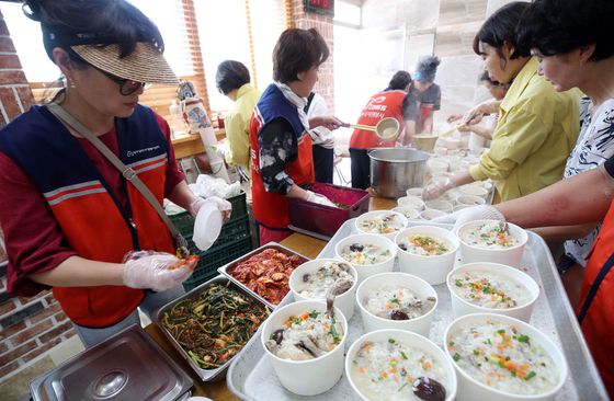 21일 광주 북구 신안동 신안교회에서 열린 수해 피해 주민 위로 삼계탕 나눔 행사에서 구청 복지정책과 직원, 솔잎쉼터 봉사단들이 수재민들에게 삼계탕 배식봉사를 하고 있다. 연합뉴스