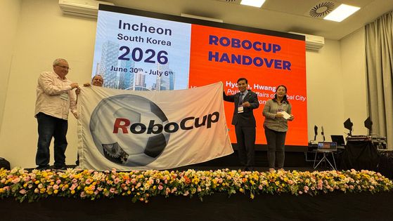 황효진 인천시 정무부시장이 브라질 살바도르시로부터 로보컵 대회기를 넘겨받고 있다. 사진 맨 오른쪽은 로보컵 조직위원인 에이로봇 엄윤설 대표. 사진 한재권 한양대 교수