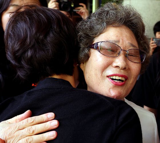 61년 전 자신을 성폭행하려던 남성의 혀를 깨물어 중상해 혐의 유죄 판결을 받았던 최말자(78)씨가 23일 부산지법에서 열린 재심 첫 공판을 마치고 법정을 나서며 변호인과 여성단체와 포옹하고 있다. 연합뉴스