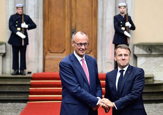 23일 프리드리히 메르츠 독일 총리(왼쪽)가 베를린의 독일 외무부 영빈관 빌라 보르시그에서 에마뉘엘 마크롱 프랑스 대통령을 환영하고 있다. AFP=연합뉴스