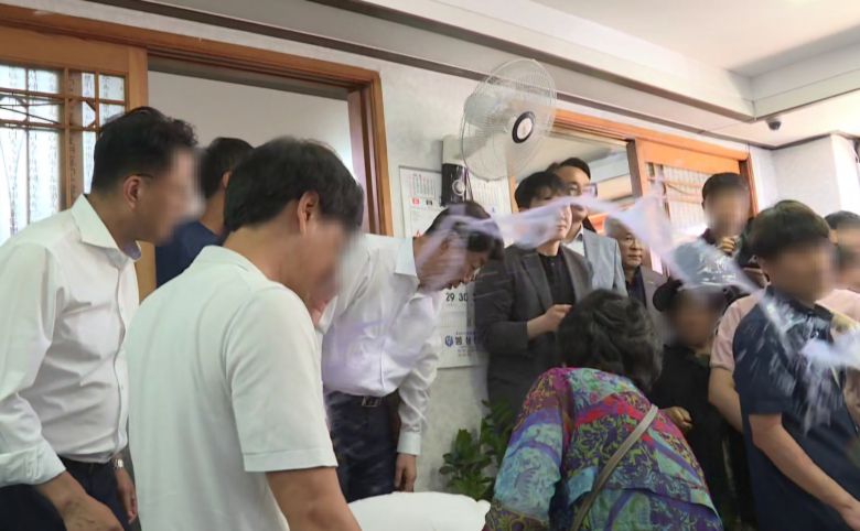 전주·완주 통합에 반대하는 완주군민에게 물벼락을 맞은 우범기 전주시장이 아무 말 없이 손수건으로 얼굴을 닦고 있다. 사진 독자