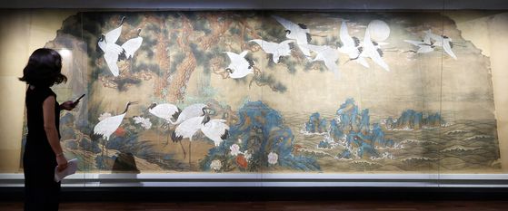 13일 서울 종로구 국립고궁박물관 2층 기획전시실에서 열린 특별전 '창덕궁의 근사謹寫한 벽화' 언론 공개회에서 참석자가 김은호 '백학도'를 살펴보고 있다. 국립고궁박물관은 14일부터 개관 20주년 특별전 '창덕궁의 근사謹寫한 벽화'에서 창덕궁 내전인 희정당, 대조전, 경훈각을 장식했던 벽화 6점을 최초로 일괄 공개한다. 뉴스1