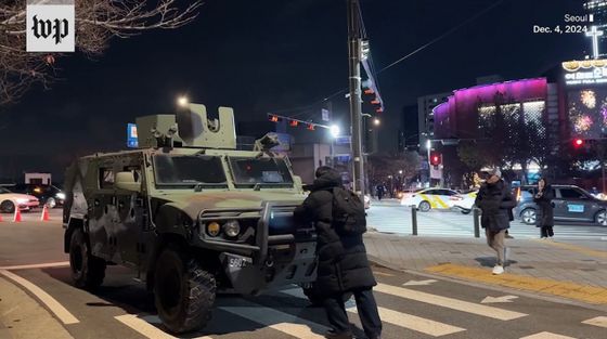 지난해 12월 3일 비상계엄 사태 당시 한 시민이 장갑차를 막아서고 있다. 워싱턴포스트 웹사이트 캡처