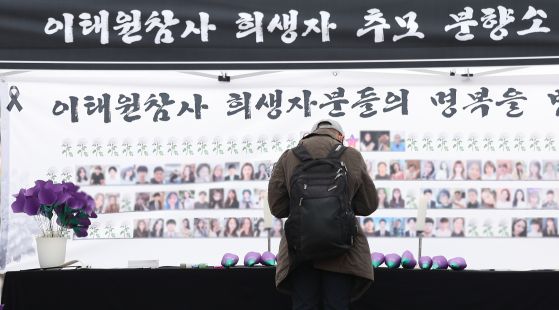 이태원 참사 2주기인 지난해 10월 대구 중구 동성로에 마련된 이태원 참사 희생자 추모 분향소에서 한 시민이 헌화 후 묵념하고 있다. 연합뉴스