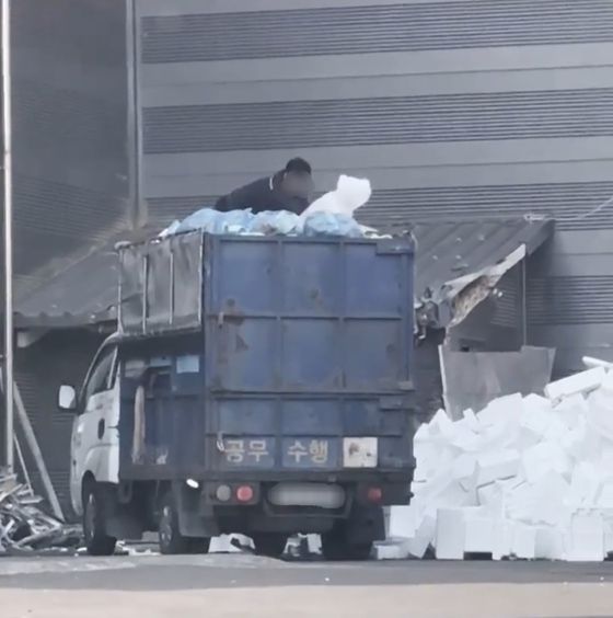 지난 7월 전주시 삼천동 민간 재활용처리업체 작업장에서 전주시와 계약을 맺은 생활폐기물 수집·운반 대행 업체 직원이 '공무 수행'이라고 적힌 재활용 쓰레기 수거 차량에 실린 스티로폼을 연신 바닥에 던지고 있다. 사진 독자
