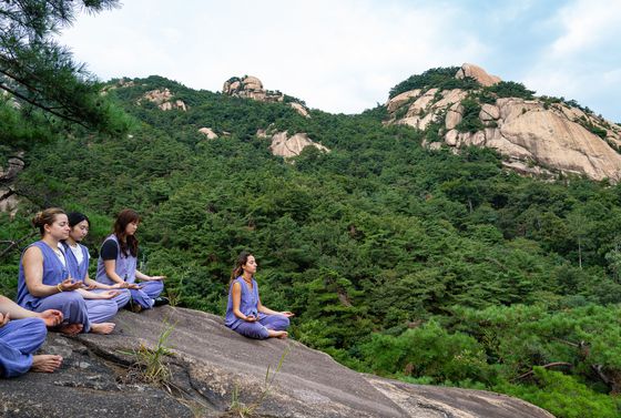 북한산 금선사 템플스테이 참가자들이 경내 언덕의 너럭바위에서 명상하는 모습.